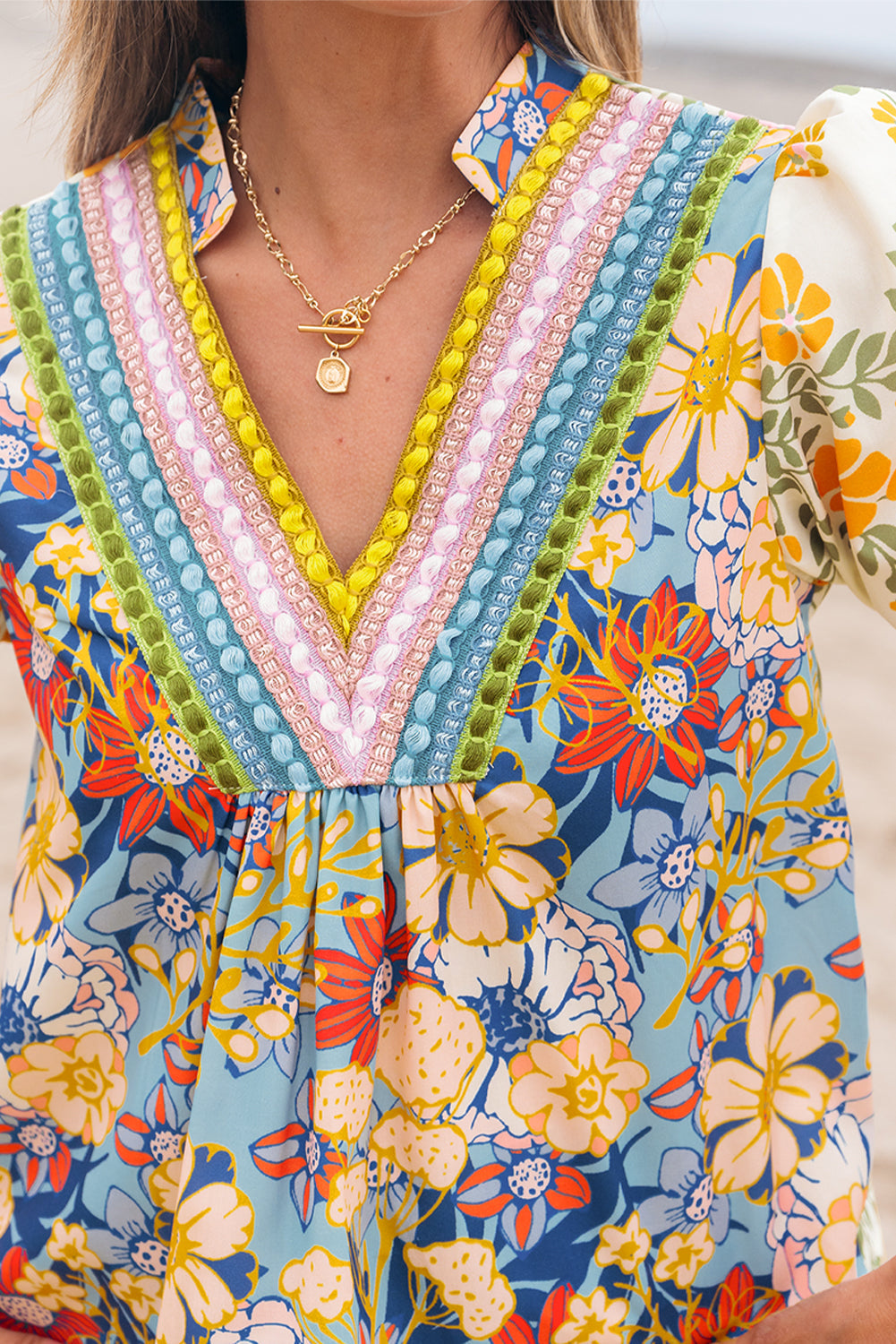 Vibrant botanical print blouse showing colorful lace crochet detailing