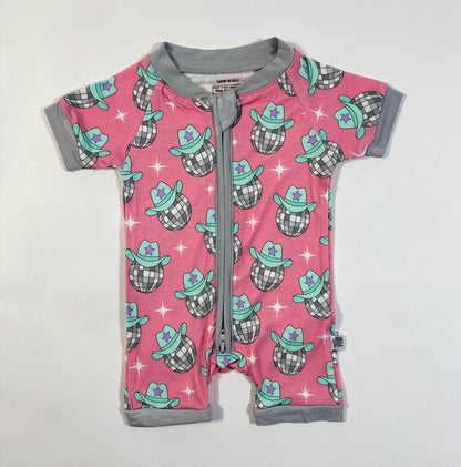 Pink baby romper with cowboy hat pattern on a white background