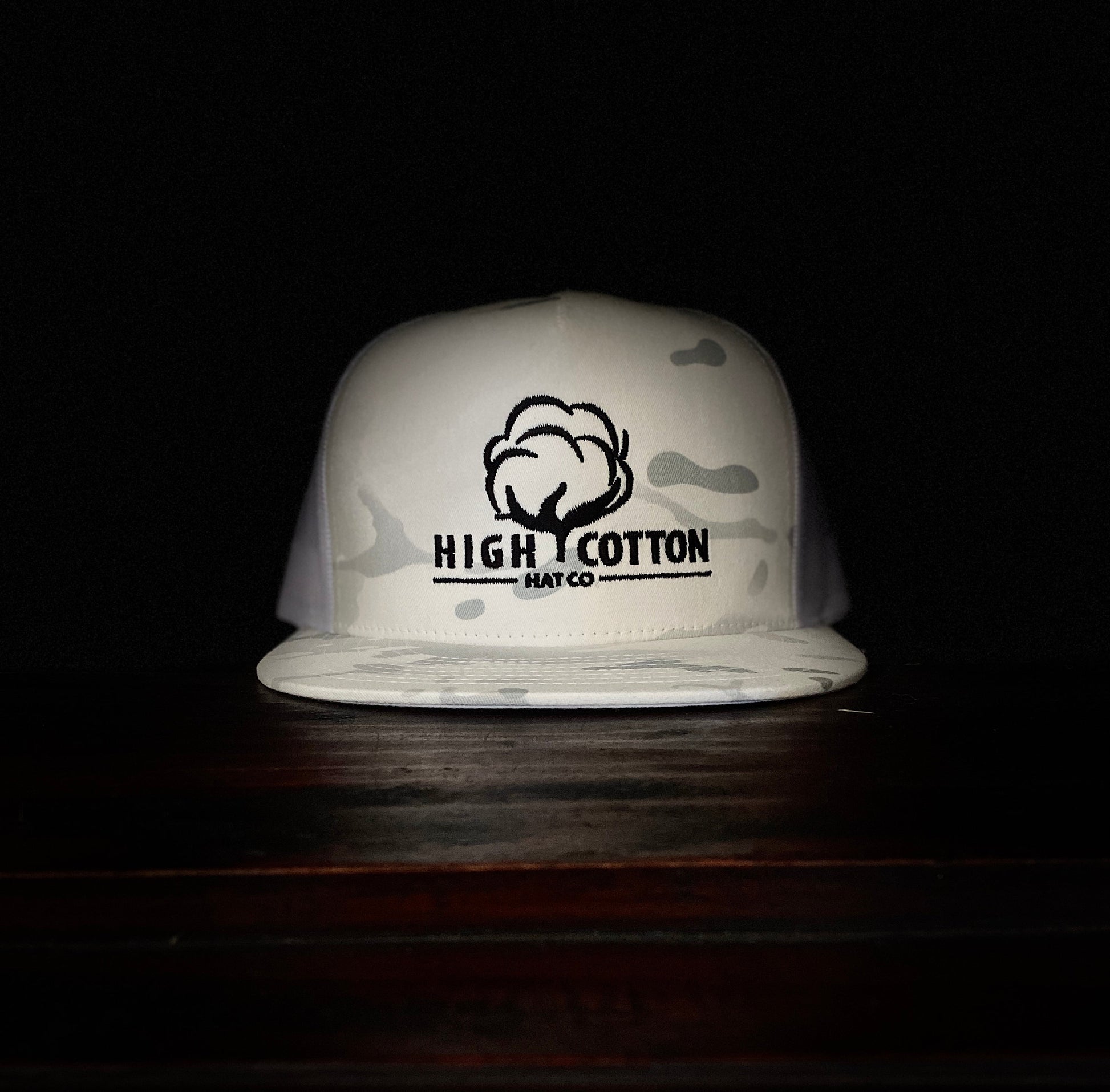 White bucket hat with 'High Cotton Hat Co' logo on a dark background