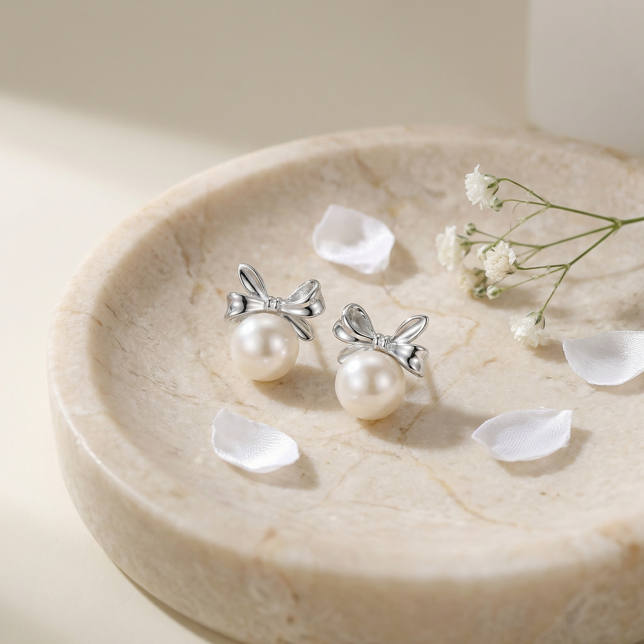 Sterling Silver Pearl Bow Earrings Flatlay with Babys Breath